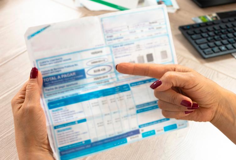 Una colombiano mirando una factura de uno de sus servicios públicos