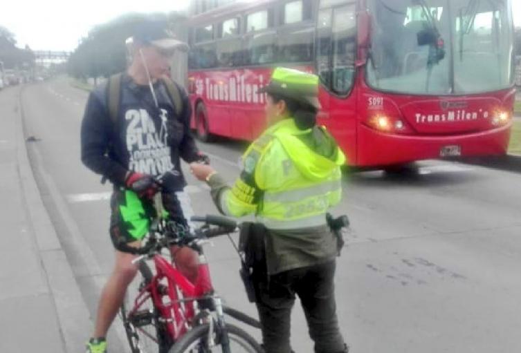 Ciclista andando por el carril exclusivo de TransMilenio 