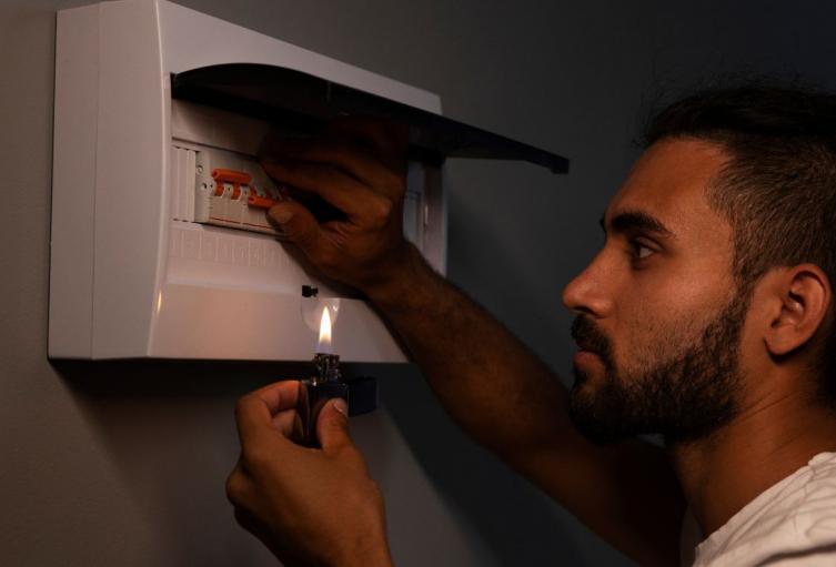Cortes de luz en Bogotá Hombre revisando la caja de energía de su vivienda