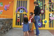 Mujer llevando a sus hijos al jardín infantil