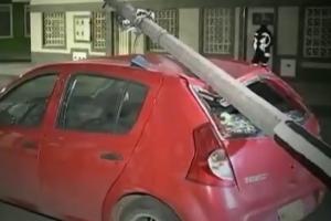 Poste cae sobre carro