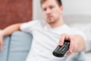 hombre usando el Control del televisor