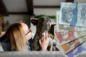 Mujer con su perro en el sofá y dinero colombiano