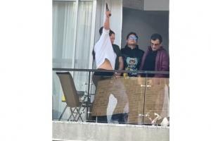 Mujer disparando al aire desde un balcón en Bogotá.