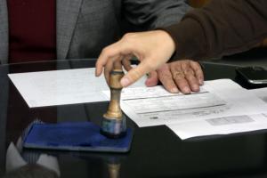 Notario firmando documento en notaría