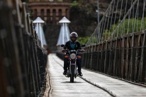 Motociclista atravesando un puente en Colombia