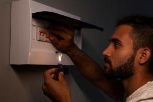 Hombre revisando la caja de energía de su vivienda
