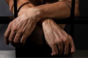 Hombre  tras las rejas de una prisión