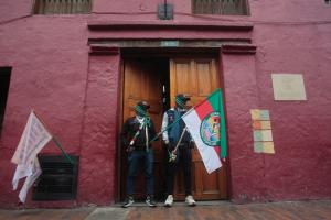 Dos integrantes de la Guardia Interétnica custodian la entrada del Ministerio de Vivienda en medio de las protestas del Congreso de los Pueblos en Bogotá.