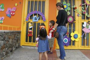 Mujer llevando a sus hijos al jardín infantil