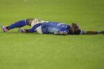 Jugador de Millonarios en el suelo en un partido.