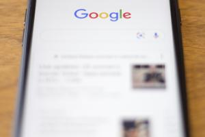 Google en la pantalla de un celular Iphone de Apple