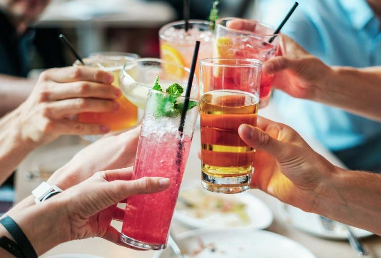 Personas brindando con bebidas tropicales