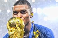 Kylian Mbappé besando la Copa del Mundo
