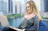 Una joven asiste una clase virtual en el exterior