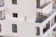 Niña caminando por el estrecho borde de un edificio  