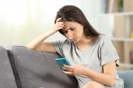 Mujer incómoda con un mensaje en su celular 
