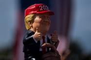 Seguidor de Donald Trump sostiene un muñeco de presidente en un evento en Tampa, Florida