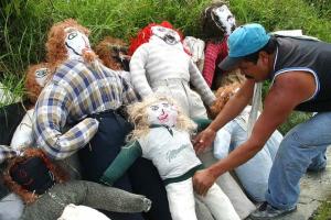 Hombre arruma distintos muñecos de trapo